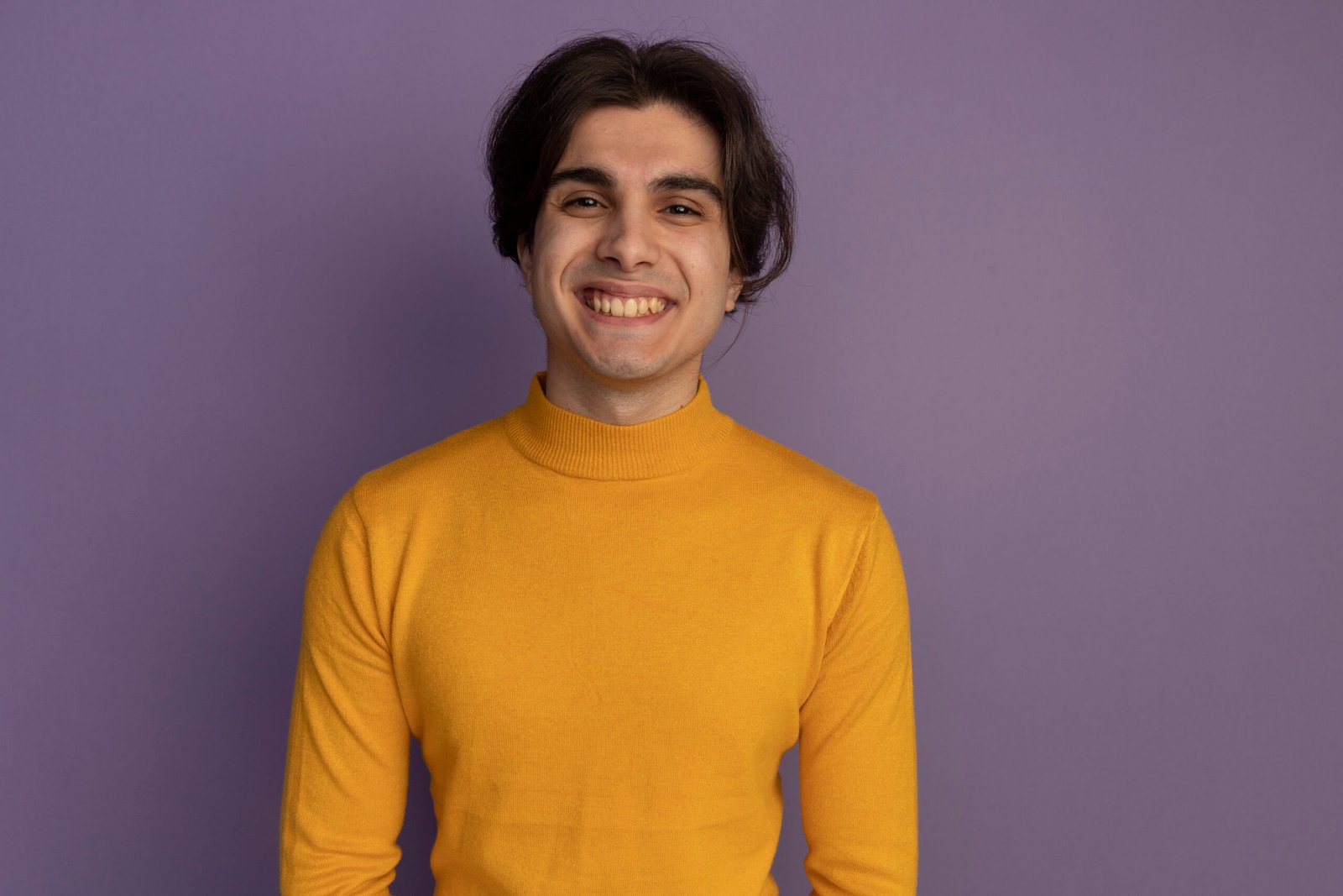 smiling young handsome guy wearing yellow turtleneck sweater isolated on purple background with copy space